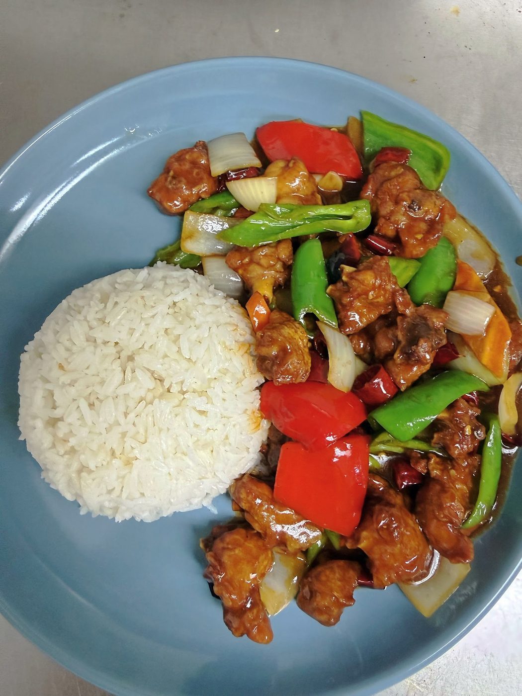 A rice plate with glazed meat and vegetables at Bomb Fried Skewers