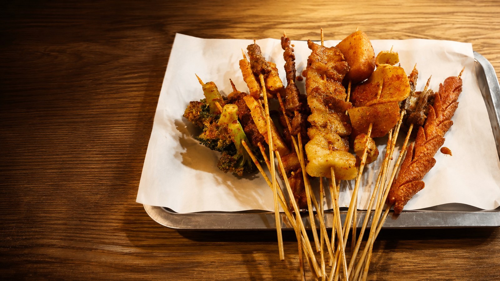 A tray of assorted fried skewers and vegetables at Bomb Fried Skewers