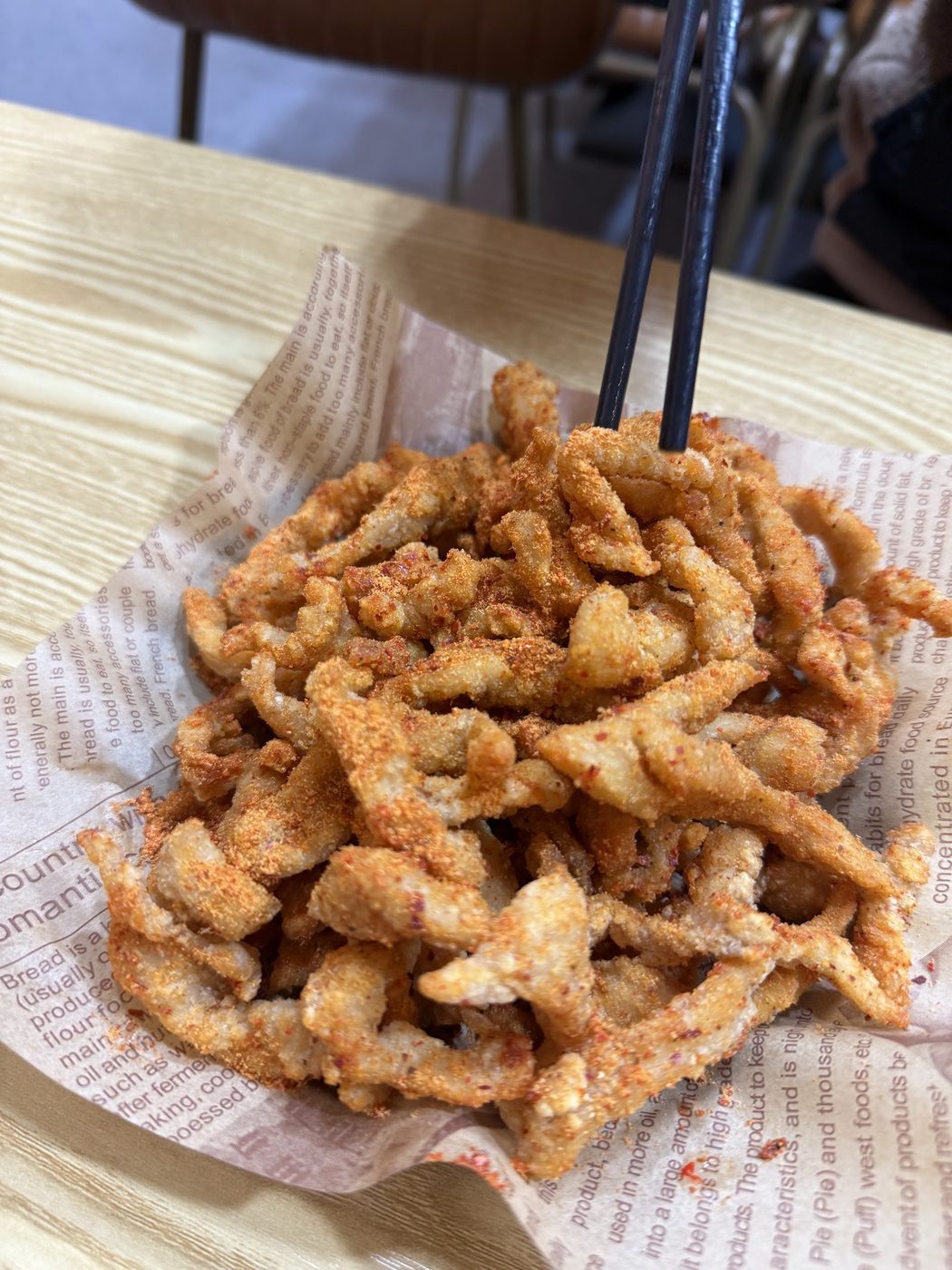 Crisp fried strips served on paper at Bomb Fried Skewers